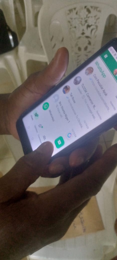 Founder in a Kigali shop explaining how SokoSense works from WhatsApp